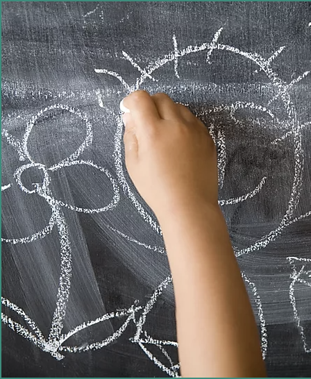 Child's hand drawing on chalkboard